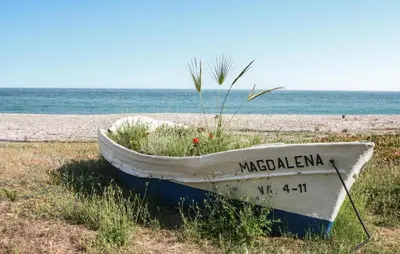 a boat sitting on the shore of a beach at Awesome Apartment In Moncofa in Moncófar