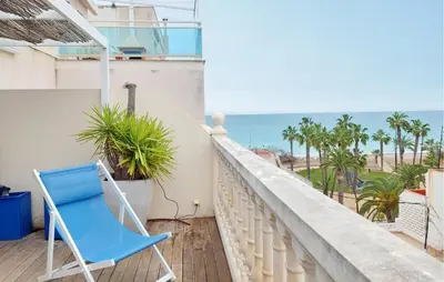a blue chair sitting on a balcony overlooking the ocean at Awesome Apartment In Moncofa in Moncófar