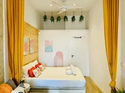a bedroom with a bed with orange curtains at Beautiful Flat NEXT the BEACH in Valencia