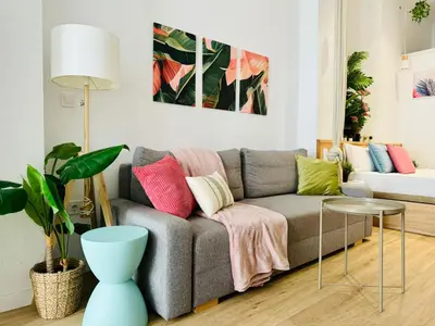 a living room with a gray couch with colorful pillows at Nice & Cozy Flat Close The Beach in Valencia