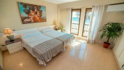 a bedroom with a bed and a painting on the wall at Apartamento familiar Port-Saplaya in Port Saplaya