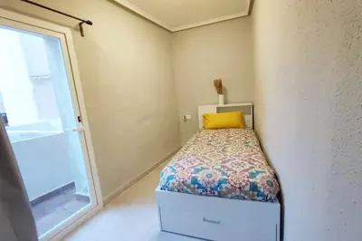 a small bedroom with a bed and a window at District Key - Lliria, Santisima Sangre in Lliria