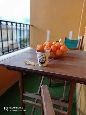 a bowl of oranges sitting on a table with a cup at La casita de Daniel in Turís