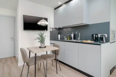 a kitchen with a table and chairs in a room at Limehome Valencia Carrer de Sant Jacint in Valencia