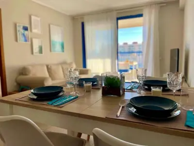 a dining room table with plates and glasses on it at Apto. luminoso con vistas en playa de La Patacona in Valencia