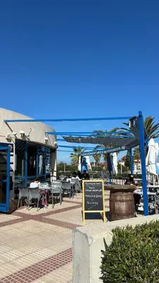 a restaurant with tables and chairs and a sign at Apto. luminoso con vistas en playa de La Patacona in Valencia