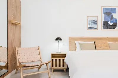 a bedroom with a white bed and a chair at Valencia Apartments by Olala Homes in Valencia