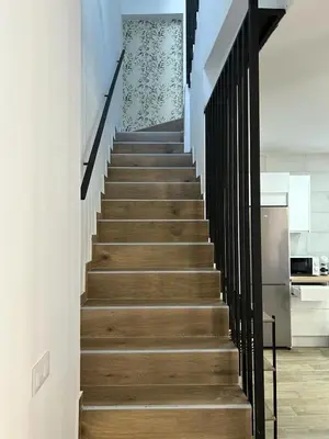 a staircase in a house with wooden floors and black railings at CAN´SELMA 1 in Chella