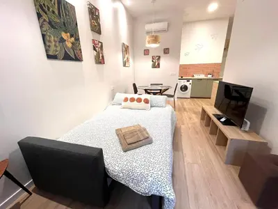 a small bedroom with a bed and a kitchen at Mestalla Garden in Valencia