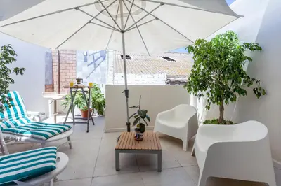 a patio with a table and an umbrella at Mediterranean Gem Getaway in Valencia