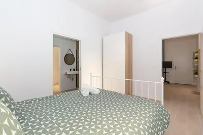 a bedroom with a bed with a gray and white comforter at GuestReady - Valencia's Vibrant Malvarrosa in Valencia