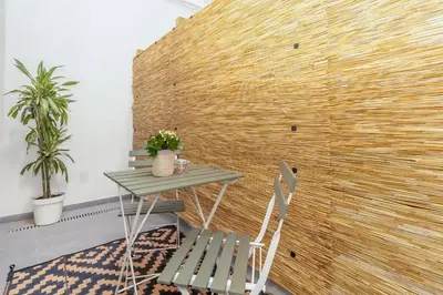 a table and chairs in front of a brick wall at GuestReady - Valencia's Vibrant Malvarrosa in Valencia