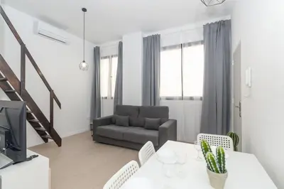 a living room with a table and a couch at GuestReady - Valencia's Vibrant Malvarrosa in Valencia