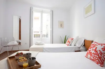 a hotel room with two beds and a tray of fruit at SingularStays Roteros in Valencia