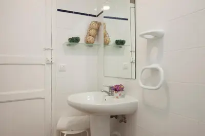 a white bathroom with a sink and a mirror at SingularStays Roteros in Valencia