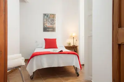 a bedroom with a bed with a red blanket at SingularStays Roteros in Valencia