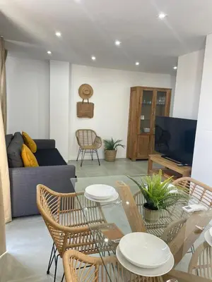 a living room with a table and chairs and a couch at UIM Mediterraneo ATICO Cendoya Wifi in Puerto de Sagunto