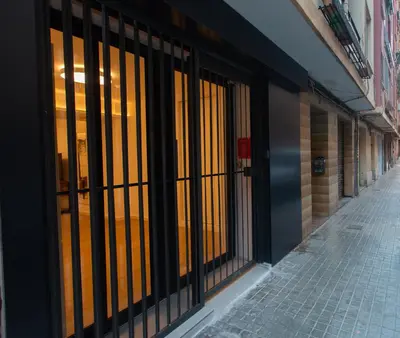 a row of glass doors on a building with a sidewalk at BatFlats - RUZAFA in Valencia