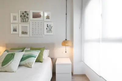 a bedroom with a bed with green and white pillows at DormForYou Jose Maria Haro in Valencia
