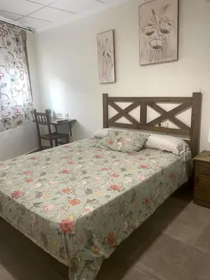 a bedroom with a bed with a floral comforter at Ca' La Conchin in Cortez de Pallas
