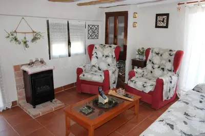 a living room with two chairs and a fireplace at Casa de pueblo en Calles in Calles