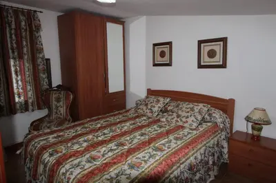 a bedroom with a bed and a lamp and a window at Casa de pueblo en Calles in Calles