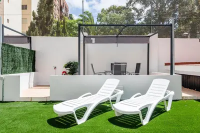 two white chairs and a table on grass at SOROLLA APARTMENTS CENTRAL Station in Valencia
