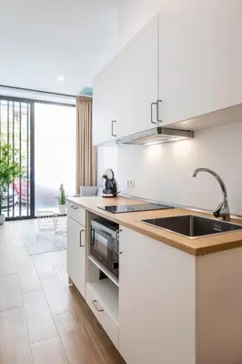 a kitchen with white cabinets and a sink at SOROLLA APARTMENTS CENTRAL Station in Valencia