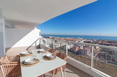 a balcony with a table and chairs and a view of the city at Global Vacacional, Moderno apartamento de dos terrazas con increíbles vistas al mar in Canet de Berenguer