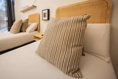 a pillow sitting on a bed in a room at FLORIT FLATS - The Pitiusas Rooms in Valencia