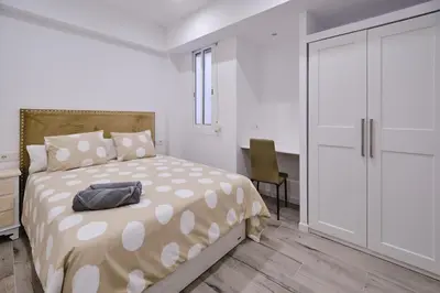 a white bedroom with a bed and a sliding door at Arenas flat in Valencia