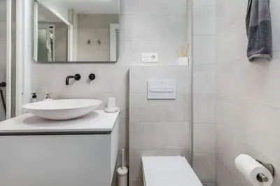 a white bathroom with a sink and a mirror at Cabanyal Sunny Beach House in Valencia