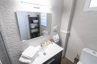 a white bathroom with a sink and a mirror at Nice lodging near the Plaza de Toros in Valencia