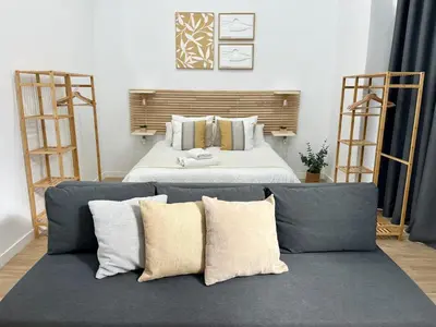 a bedroom with a couch and a bed with pillows at Loft cerca de playa y Ciudad de Artes y Ciencias in Valencia