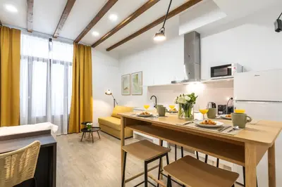 a kitchen and living room with a table and chairs at Moontels Plaza de Vannes in Valencia