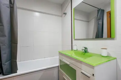 a bathroom with a green sink and a mirror at Lujoso apartamento de dos habitaciones en la playa de Canet in Canet de Berenguer