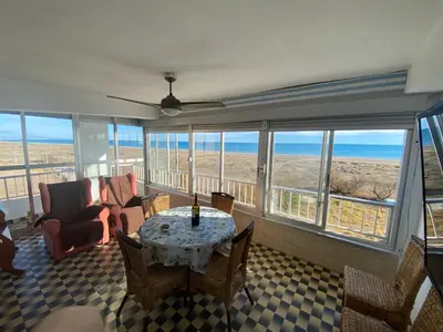a living room with a table and chairs and the ocean at Primera línea de playa in Valencia