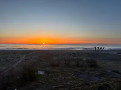a sunset on a beach with the ocean and the horizon at Primera línea de playa in Valencia