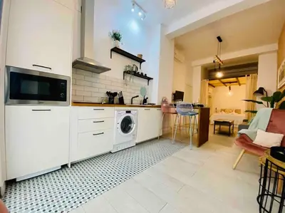 a kitchen with a washing machine and a living room at Beautiful LOFT in the HEART of Ruzafa, SOHO in Valencia