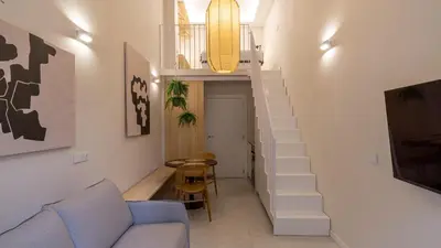 a living room with a staircase and a blue couch at Osito Hub - Poeta Durán in Valencia
