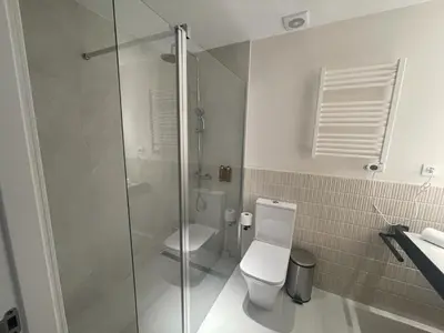 a bathroom with a toilet and a glass shower at Osito Hub - Poeta Durán in Valencia