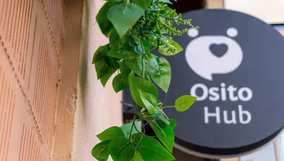 a sign on the side of a building with a plant at Osito Hub - Poeta Durán in Valencia