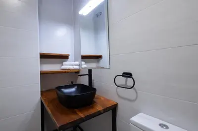 a bathroom with a black bowl on a wooden counter at Cruz Cubierta Apartments in Valencia