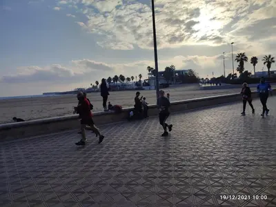 a group of people walking on a sidewalk near the beach at Central Rooms - Valencia City Centre Boho-Cozy Downtown - VLC Urban Rental in Valencia