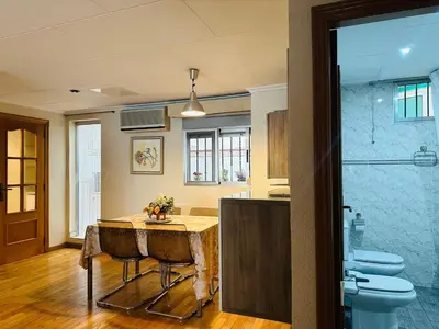 a kitchen with a table and a toilet in a room at La casa de Lili acerca de palacio de música in Valencia