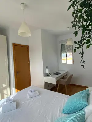 a bedroom with a white bed and a desk at SingularStays Valero III in Valencia