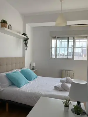 a bedroom with a large bed with blue pillows at SingularStays Valero III in Valencia