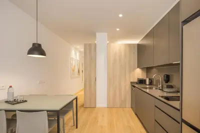 a kitchen with a table and a counter top at Mon Suites Jardín de Ayora in Valencia