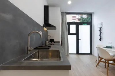 a kitchen with a stainless steel sink and a table at Nuevo loft en playa y cerca del centro, AC y Wifi in Valencia