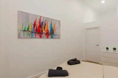 a white room with a painting hanging on a wall at Nuevo loft en playa y cerca del centro, AC y Wifi in Valencia